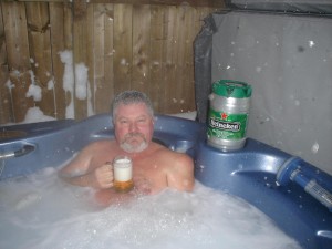 Pat drinking a beer in a hot tub in winter